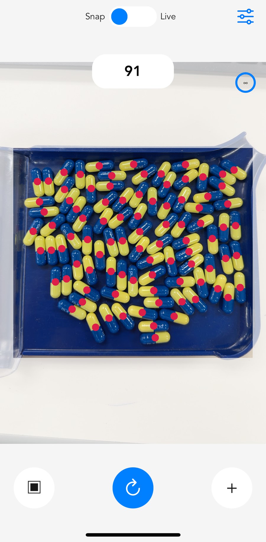 pillphill counting a tray of two-tone capsules